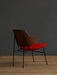 A three-quarter rear view of The Penguin Lounge Chair with a walnut veneer back, red upholstered seat, and black steel frame.