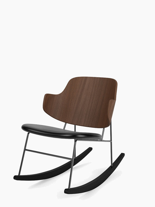 Angled view of The Penguin Rocking Chair with a walnut veneer back, black leather seat, and a black steel frame.
