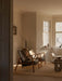 Two Seal Lounge Chairs in dark leather and a stone Androgyne Lounge Table arranged in a serene, sunlit living room.