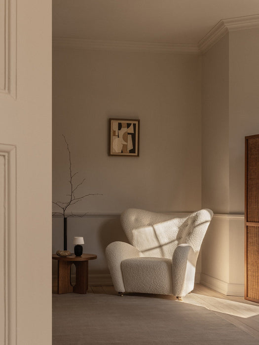 The Tired Man Lounge Chair, Androgyne Side Table, and Torso Table Lamp styled in a serene, sunlit corner with abstract art.