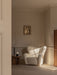 The Tired Man Lounge Chair, Androgyne Side Table, and Torso Table Lamp styled in a serene, sunlit corner with abstract art.