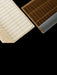 A cream rug and a brown rug, both with a tactile grid pattern. The rugs are rolled back, revealing their different backings.