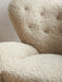 Close-up of The Tired Man Lounge Chair's plush, off-white sheepskin upholstery, detailing the tufted backrest and soft seat.