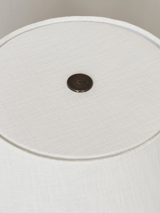 Overhead close-up of the Torso Table Lamp's textured white linen lampshade, featuring the circular, dark brass touch dimmer.