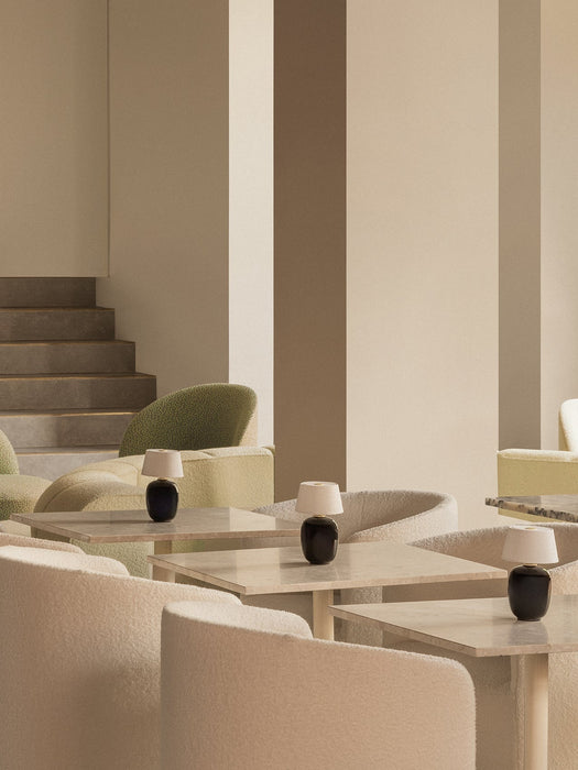 A lounge with Torso Portable Table Lamps on Nook Dining Tables, surrounded by plush Tearoom Club Chairs in a neutral palette.