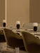 Three Torso Portable Table Lamps illuminate marble tables beside plush, green Harbour Dining Chairs in a modern interior.