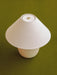 Overhead view of the Torso Table Lamp, 37. It has an off-white linen shade, brass dimmer, and rounded ceramic base.