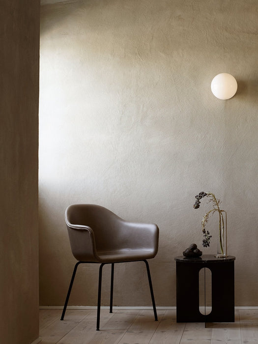 The TR Bulb Ceiling/Wall Lamp illuminates a corner with a Harbour Chair and an Androgyne Side Table holding a Stem Vase.