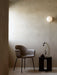 The TR Bulb Ceiling/Wall Lamp illuminates a corner with a Harbour Chair and an Androgyne Side Table holding a Stem Vase.