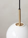 A close-up of the TR Bulb, Pendant light, detailing the brushed brass fixture emerging from the white opal glass globe.