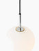 Detail shot of the illuminated TR Bulb Pendant, with a glowing opal glass bulb, polished steel fixture and black cord.