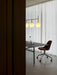 A TR Bulb Suspension Frame lamp hangs over a black dining table with a brown Harbour Side Chair in a minimalist room setting.