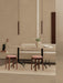 A serene dining space with two Tubulaire Pendant Lamps, a beige Eave Dining Sofa, and Passage Stools with pink upholstery.