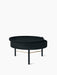 The round, black ash Turning Table, its top pivoted open to reveal storage. It has three legs with a brass accent bar.