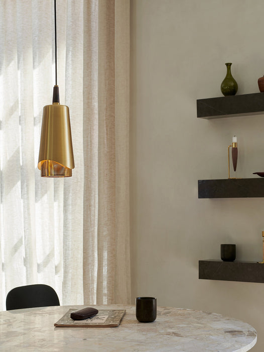 The brass Umanoff Pendant hangs over a marble table. In the background are Plinth Shelves with Umanoff & Duca candleholders.