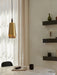 The brass Umanoff Pendant hangs over a marble table. In the background are Plinth Shelves with Umanoff & Duca candleholders.