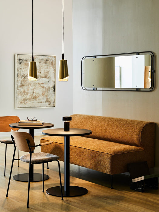 A modern dining area with two Umanoff Pendants, an Eave Dining Sofa, a Co Chair, a Column Table Lamp, and a Nimbus Mirror.