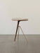 The Umanoff Side Table with a tripod base of brass and walnut, supporting a round walnut top with a brass rail.