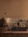 A Vilhelm Sofa in a warm-toned living room with a Saxe Lounge Chair, a black marble Plinth, and a Wing Floor Lamp.