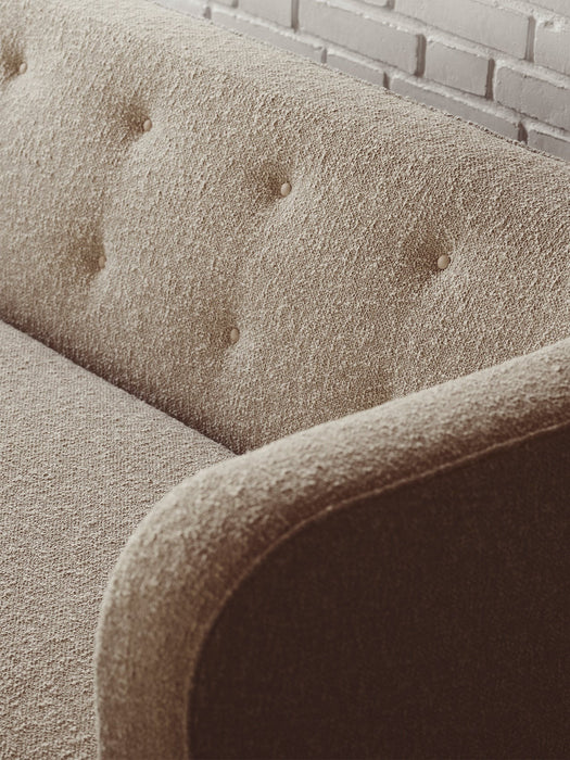 A detailed close-up of the Vilhelm Sofa's button-tufted backrest, showing the rich texture of the light brown upholstery.