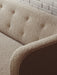 A detailed close-up of the Vilhelm Sofa's button-tufted backrest, showing the rich texture of the light brown upholstery.