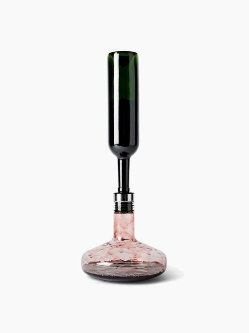 A dark green wine bottle is inverted, decanting red wine through an aerator into the wide-based glass Wine Breather Deluxe.