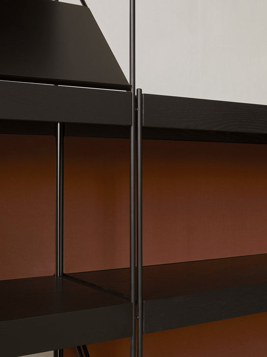 Close-up of a modern black shelving unit, highlighting the connection between the thin black metal frame and the shelves.