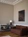 Zet Storage System in Dark Stained Oak with a black frame, styled in a classic living room next to a brown sofa.