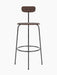 A front view of the Afteroom Bar Chair, Veneer, in dark stained oak with a slim, black powder-coated steel frame.
