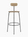 A front view of the Afteroom Bar Chair, showing its black steel frame, upholstered beige seat and natural oak backrest.