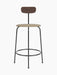 Front view of the Afteroom Counter Chair with a dark stained oak backrest, a beige bouclé seat, and a thin black steel frame.