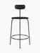 Front view of the minimalist Afteroom Counter Chair in black, with an upholstered seat, steel frame, and low wooden backrest.