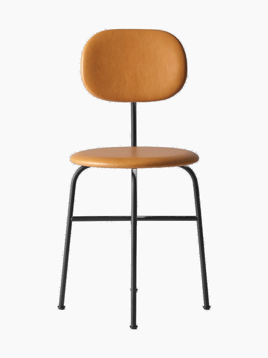 The Afteroom Dining Chair Plus with a slim black frame. The round seat and oval backrest are upholstered in tan Dakar leather