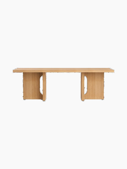 The Androgyne Lounge Table in natural oak. A long, low rectangular table with two solid legs featuring distinctive cutouts.