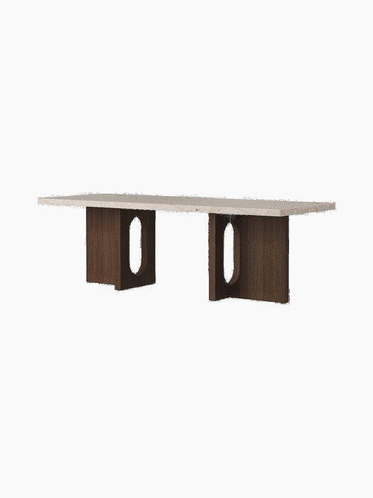 The Androgyne Lounge Table with a rectangular Kunis Bressia stone top and a dark stained oak base with distinctive cutouts.