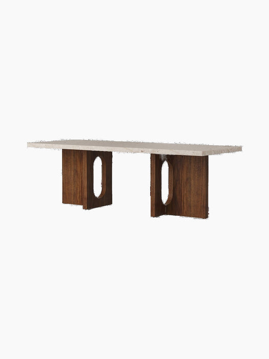 Androgyne Lounge Table with a rectangular Kunis Breccia stone top resting on two wide walnut veneer legs with oval cutouts.