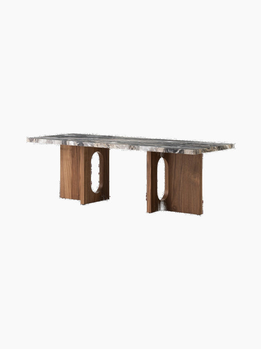 Angled view of the Androgyne Lounge Table, featuring a walnut wood base with oval cutouts and a veined marble tabletop.