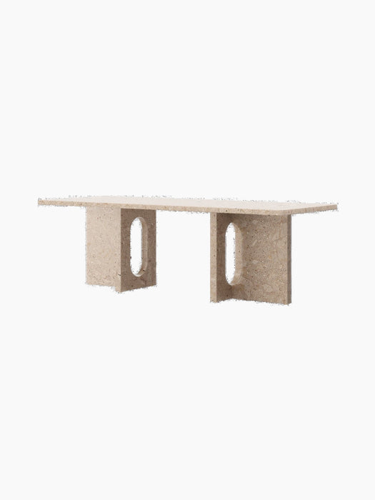 Angled view of the Androgyne Lounge Table in Kunis Breccia stone, with a rectangular top and legs with oval cutouts.