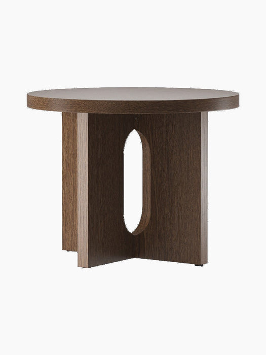 The Androgyne Side Table, Ø50, in dark stained oak. The round table features a base with wide, flat legs and an oval cutout.