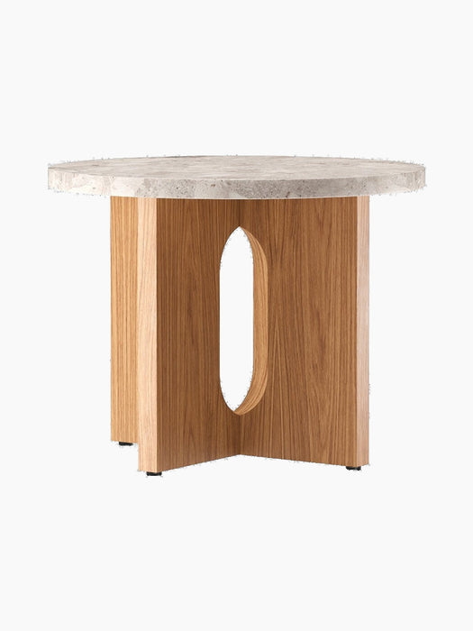 Angled view of the Androgyne Side Table, Ø50, with a round Kunis Breccia stone top and a natural oak base with oval cutout.