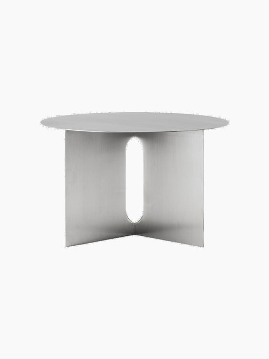 Angled front view of the Androgyne Side Table Ø63 in brushed steel, showing its round top and base with an oval cutout.