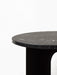 A close-up of the Androgyne Side Table, showing its round black marble top with white veining against a neutral background.