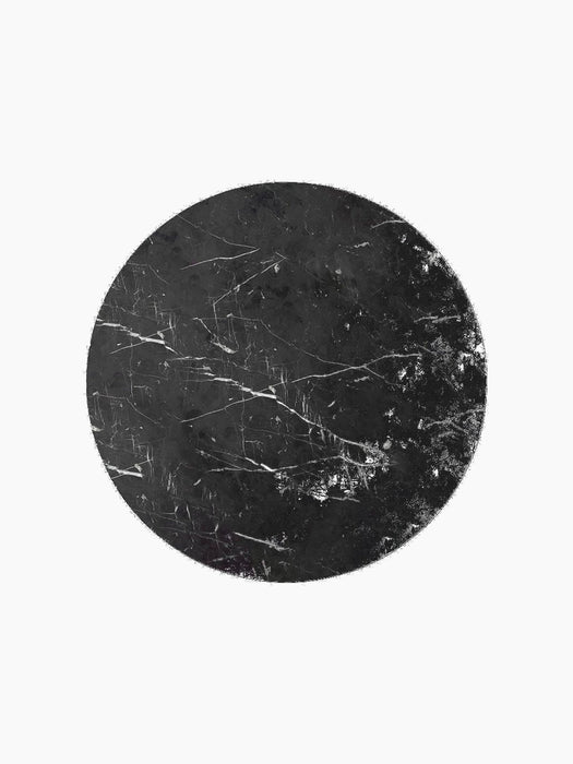 A top-down view of the circular Androgyne Side Tabletop in black Nero Marquina marble, showing its intricate white veining.