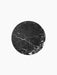 A top-down view of the circular black marble tabletop for the Androgyne Side Table, showing its intricate white veining.