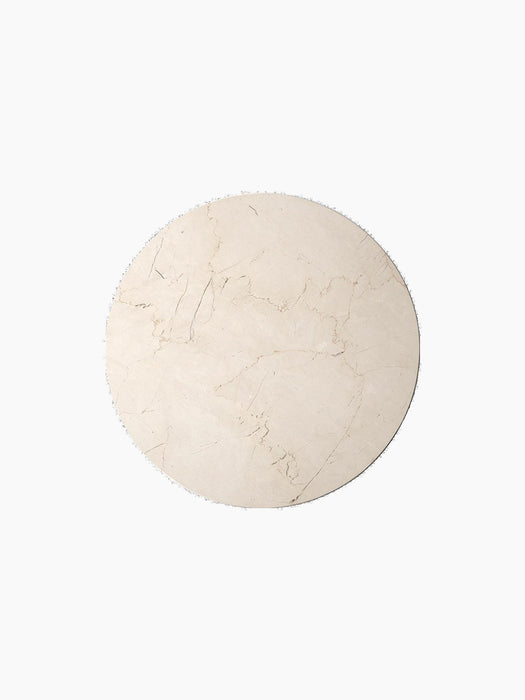A top-down view of the round, ivory marble tabletop for the Androgyne Side Table, shown against a plain black background.