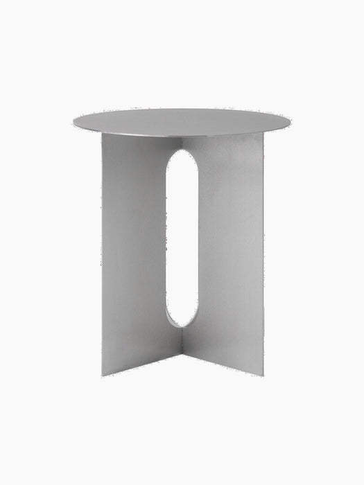 The steel Androgyne Side Table, Ø40, has a round top and three flat legs, each featuring a long, rounded cutout.