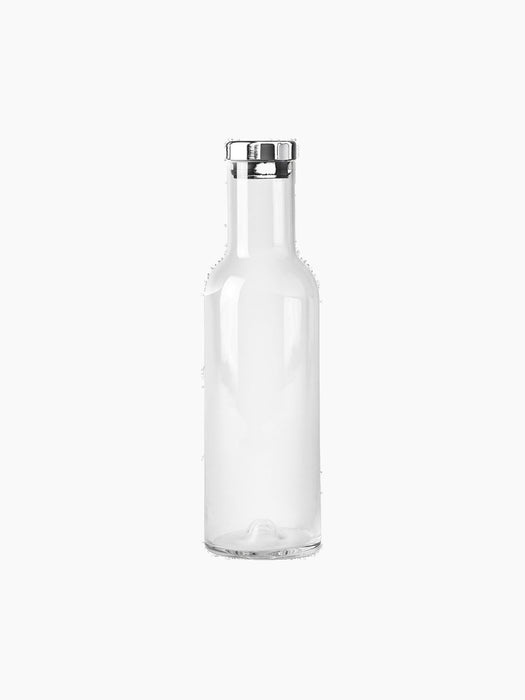A front-view, studio shot of the Audo Bottle Carafe with Steel Lid. The minimalist carafe is made of clear glass.