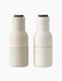 A pair of Bottle Grinders in a sand-coloured ceramic with a speckled finish and a dark wood lid, on a plain black background.