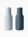 The Bottle Grinder set in light and dark blue. The minimalist, bottle-shaped grinders have matte finishes and wood tops.