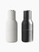 A pair of minimalist Bottle Grinders from Audo CPH, one in matte Ash and one in matte Carbon, both with brushed steel lids.